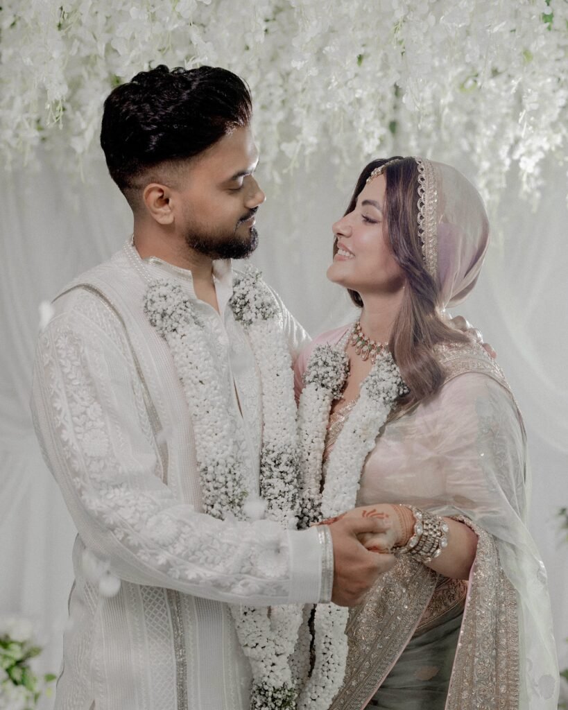 हिना ने अपनी शादी के लिए ओपल ग्रीन हैंडलूम साड़ी चुनी, जिस पर सोने और चांदी के धागों से पारंपरिक डिजाइन बुने गए थे। साड़ी के हल्के गुलाबी बॉर्डर पर जरदोजी और बारीक कढ़ाई ने इसे और भी खास बना दिया। उन्होंने अपने और रॉकी के नाम को साड़ी पर कढ़वाया, जिससे यह लुक और भी यादगार बन गया।